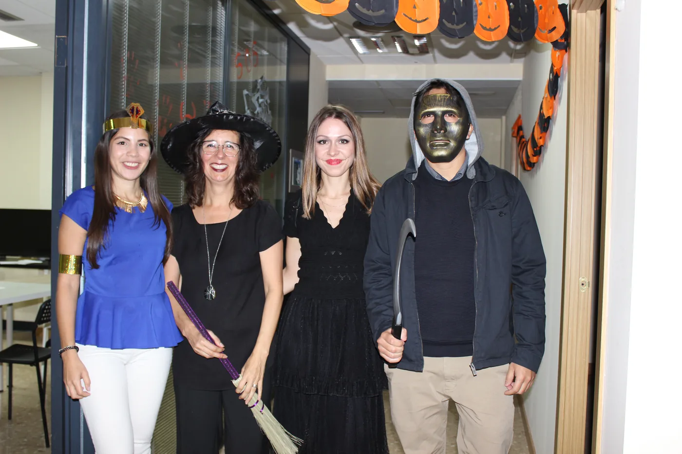 Four students in costume at the classroom door at Halloween