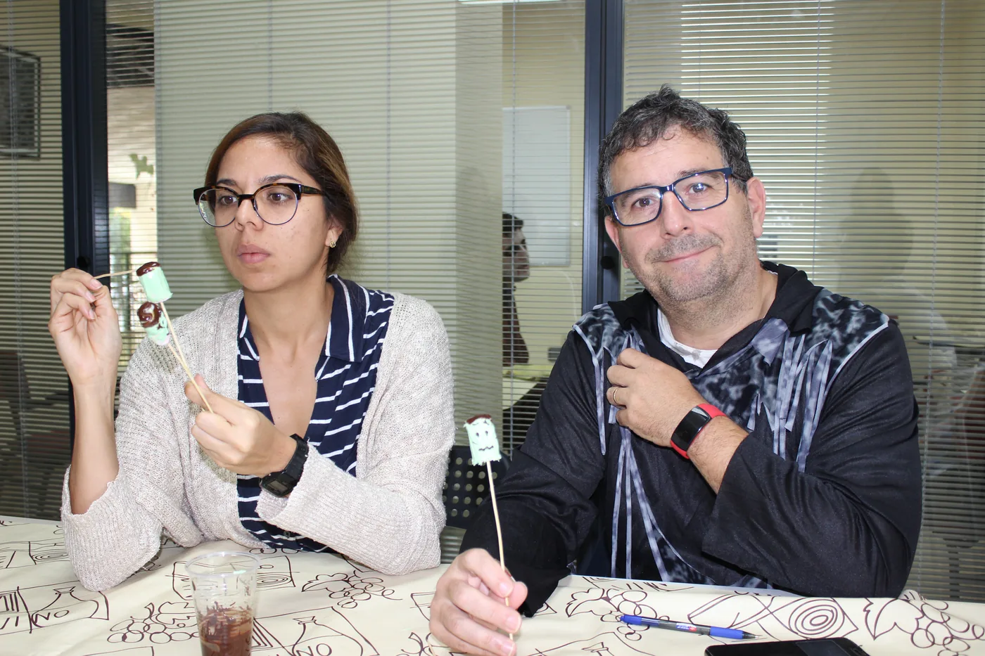 Two students with Halloween lollipops at the classroom table