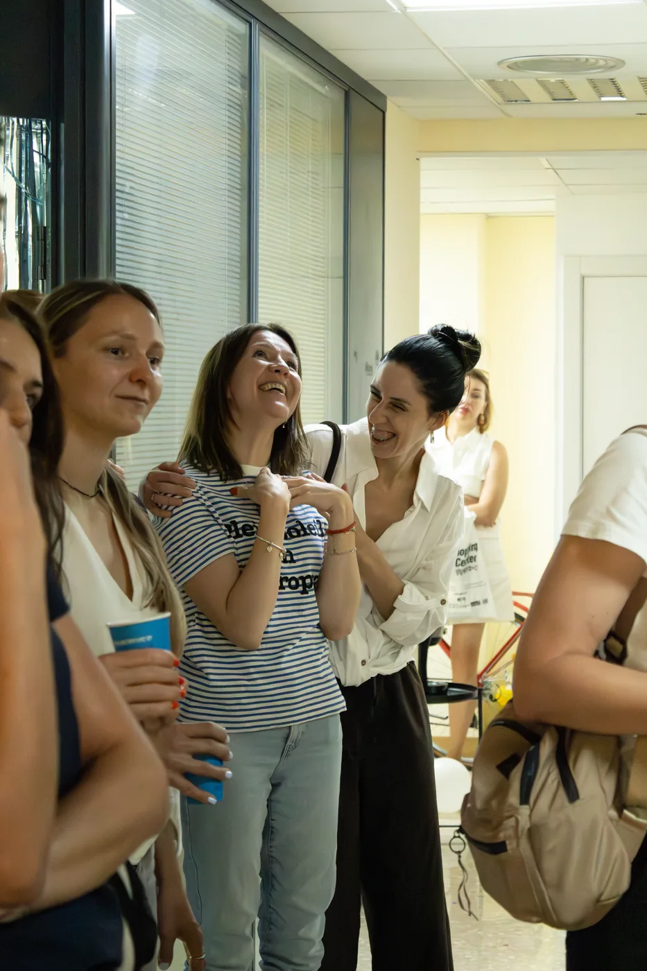 Students laughing and clapping in the school corridor