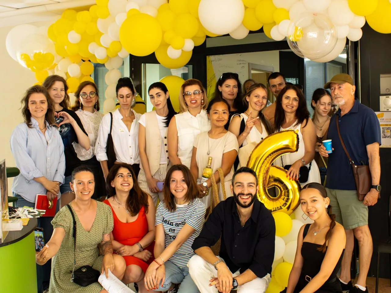 School family photo with the number-six balloon and yellow balloons