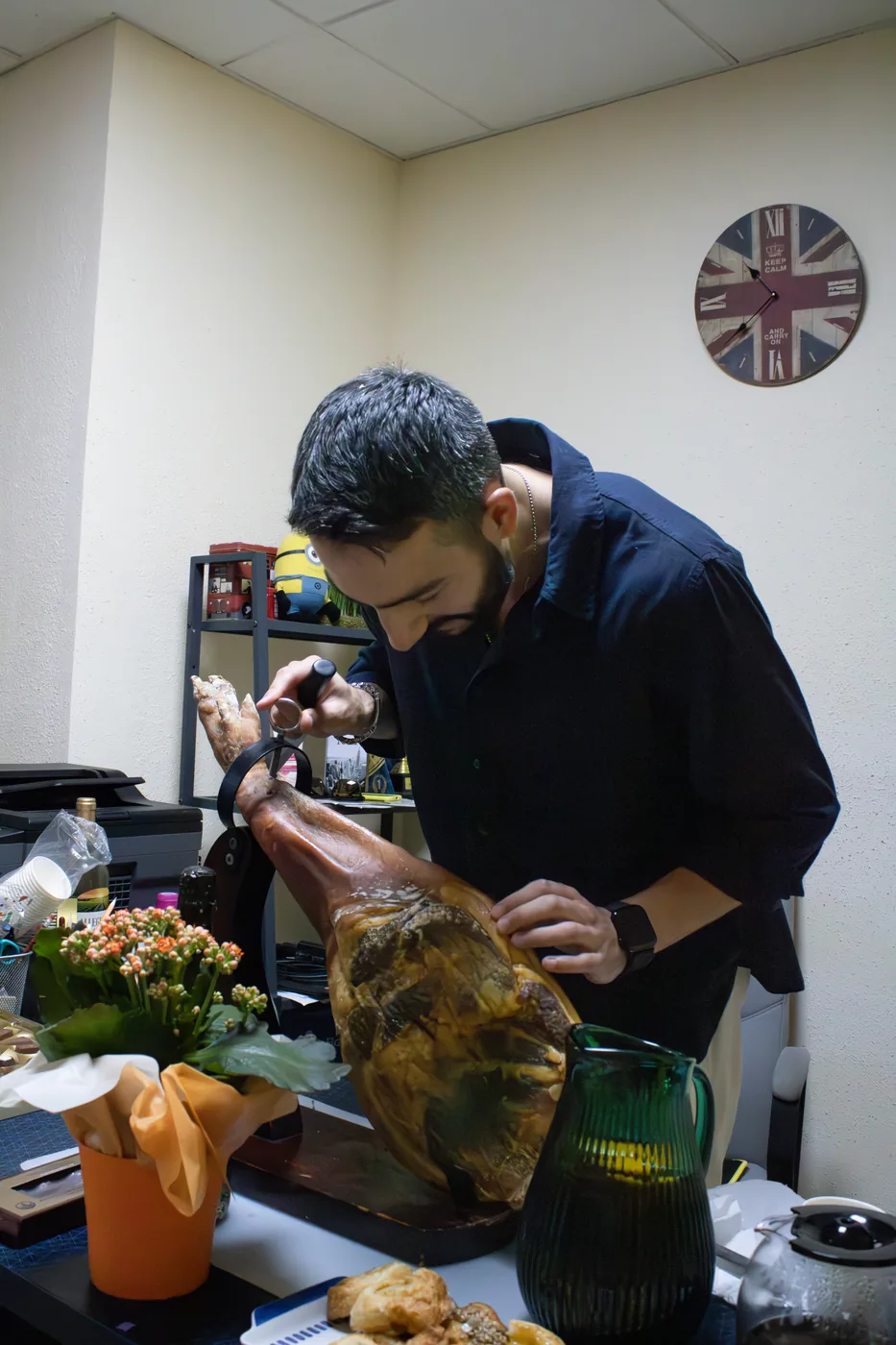 A teacher carving jamón for students at the school party