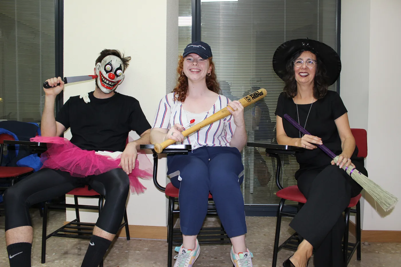 Three students with a clown mask and a witch’s broom at Halloween