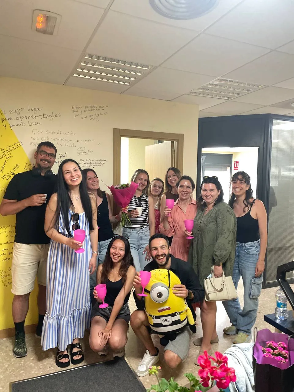 Last photo of the course with students, flowers, pink cups and the minion